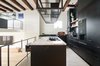 Modern home with Kitchen, Marble Counter, and Metal Cabinet. On the side of the home that faces the canal, the main kitchen’s aesthetic is decidedly elemental. Custom Eginstill hot-rolled steel cabinetry with recessed Gaggenau appliances surround a Carrara marble island. Photo 5 of Bloemgracht