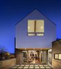 Modern home with Outdoor, Back Yard, Wood Fences, Wall, Horizontal Fences, Wall, Grass, and Stone Patio, Porch, Deck. “We were concerned that by elevating the first floor by six feet, we would be detaching the living space from the neighborhood,” Mitchell says. “Thus, we have an elevated exterior patio off of the rear that overlooks the sidewalk and brings the living space to the outdoors.” Photo 7 of Highlands House
