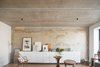 Crosby Studios eventually found this rust-washed concrete wall underneath many layers of wallpaper. “Nobody even thought to paint it,” explains Dmitry. “The ceiling was polished until it was concrete, and then covered in laquer.” Photo of Soviet Intelligentsia modern home