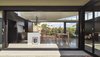 A range by Falcon stands in the kitchen; Apollo pendants by Masson for Light hang above the island. Polished concrete flooring acts as a uniting tone between the room's black and white surfaces. Photo 2 of Breeze modern home