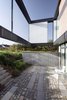 Local building codes dictated that the structure should only be a single story and could only occupy 20 percent of the property. The architects cleverly designed downward to create a basement-level living space. Photo 3 of Villa R modern home