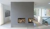Modern home with Living Room, Wood Burning Fireplace, and Corner Fireplace. Scandinavian architecture firm C.F. Møller designed a serene, zinc-clad home in Aarhus, Denmark. On the interior, a large, three-sided fireplace incorporated into a floating wall helps connect two spaces and warm up the home, and the wall also incorporates a purpose-designed niche filled with firewood for easy re-stoking. Photo 6 of Villa R