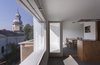 The main issue Lucerne-based architect Andreas Heierle faced during this attic renovation in Bucharest, Romania, was bringing natural light into the cloistered, closed-off rooms. His client, a bachelor in his 30s, wanted a floorplan that was flexible and open, a radical departure from the cramped, dark upper levels normally found in these types of apartment buildings. Heierle installed large windows, which flood the space with sunlight and provide a view of the church across the street. Photo of Minimal Romanian Attic Renovation Complete with an Epic Bathtub modern home