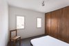 The calming, minimal bedroom follows the same design direction as the rest of the home; simple color contrasts, with the earthiness of the oak playing against the stark white walls, and custom woodwork. The house benefits from radiant heating in the floor and insulation and soundproofing in every wall. Photo of Minimal Romanian Attic Renovation Complete with an Epic Bathtub modern home