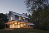 Modern home with Exterior, Gable RoofLine, Metal Roof Material, and House Building Type. “The main volume presents a traditional front and is wrapped on the west and south by a deep porch,” says architect Erin Sterling Lewis. “Living and dining spaces access the porch.” A standing seam metal roof with a Kynar finish and HardiePlank Lap Siding cover the exterior of this 3,000-square-foot home. Photo of The Farmhouse