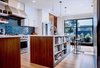 A first priority for the kitchen was sunlight: to maximize exposure, Mitchell Holladay Architects demolished as many walls as possible without compromising the home's structural integrity. LEM Piston stools by Shin and Tomoko Azumi from Design Within Reach flank a custom walnut kitchen island; sculptural hand-blown glass pendants from John Pomp Studios hang overhead. Photo of A Fresh Kitchen Update for the Family That Cooks Together modern home