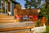 Modern home with Outdoor, Wood Patio, Porch, Deck, and Small Patio, Porch, Deck. An eight-foot-high sliding glass door leads to the backyard's ipe deck, ideal for informal gatherings. The bench cushions are custom from Studio Collins Weir and the tables and chairs are from Design Within Reach. Photo of A Fresh Kitchen Update for the Family That Cooks Together