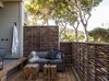 The 12 new suites range from 400-600 square feet, including an outdoor living area. The sofa and occasional tables are from Restoration Hardware and the proch railing is made from woven willow branches. Photo of A Serene Hotel in Carmel, California modern home