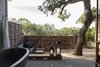 "My philosophy is to keep it simple," Hollis says. "I prefer to work with natural materials such as wood, steel, concrete, rope, and burlap, and to see how they interact with each other." A live oak tree shades the deck. The lanterns are from Restoration Hardware, with custom wiring and modifications from Hollis's team. Photo of A Serene Hotel in Carmel, California modern home