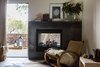 The double-sided fireplace is wrapped in a custom surround made fron Cor-Ten steel. The rocker is vintage and the artwork is from the Lost Art Salon. Photo of A Serene Hotel in Carmel, California modern home