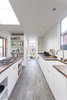 The kitchen, framed by Loewen windows, features walnut butcher block countertops, custom made by Dovetail, a Hansgrohe faucet, Franke apron sink, Miele refrigerator and oven, and Thermador cooktop. Photo 5 of Central District Residence modern home