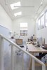 The double-height artist studio showcases custom pieces by Dovetail, like a metal handrail and maple work tables, as well as Eames Aluminum Group chairs. The goal for the home, says Heliotrope principal Mike Mora, was to, “Create an interior space akin to an art gallery with white wall surfaces adequate to hang art." Photo 7 of Central District Residence modern home