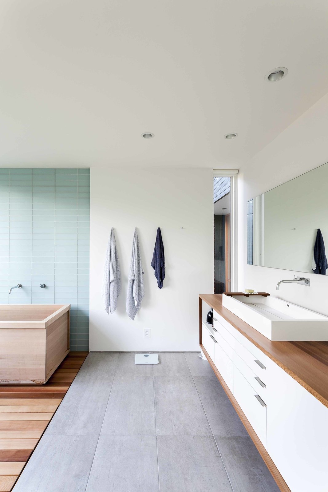 The owners were passionately involved in every aspect of the design, and pushed the team to make choices they normally might not have, including using Western red cedar for the master bathroom countertop. The spa-like space features a soaking tub, tile from Statements Urban, an MTI sink, a custom mirror, and a Vola faucet.