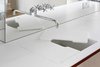 Modern home with Bath Room, Quartzite Counter, and Undermount Sink. A Dornbracht tap sits above a custom-built glacier white Corian countertop and sink. The sink is covered by a removable cutting board that can be kept in place for an added work surface, or removed for dedicated sink use. The cutout in the center allows water from the tap to flow straight through to the custom Corian drainer. Photo of Brass Is Everywhere at this Classical-Meets-Modern Flat in London