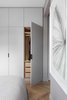 Fabric-clad wardrobe doors custom designed by INTERIOR-iD, along with Joseph Giles leather pulls, add texture to the master bedroom. Photo of Brass Is Everywhere at this Classical-Meets-Modern Flat in London modern home