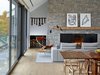 Modern home with Living Room, Floor Lighting, Light Hardwood Floor, Sofa, End Tables, Wood Burning Fireplace, and Chair. Perhaps the family’s biggest priority was their connection to the outdoors. The north-facing facade is almost entirely made up of operable windows with screens for ventilation and—a favorite of Jeff, the family father—listening to the lullabye of cicadas and spring peeper frogs during the summer.
The joint living and dining area features a Wishbone chairs by Hans Wegner for Carl Hansen & Son, a Groundpiece sofa from Flexform, David Weeks' Tripod No. 303 floor lamp, and PP Møbler's Circle Chair and Fruit Table. The latter two are also by Hans Wegner. Photo of 17 Modern Homes With Hans Wegner Furniture