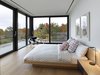 Modern home with Bedroom, Light Hardwood Floor, Table Lighting, Floor Lighting, Bed, Night Stands, and Chair. Natural light throughout the house eliminates the need for excessive overhead lighting. The master bedroom features a Pixo Optical LED table lamp, a Halyard chair by Hans Wegner for PP Møbler Flag, and David Weeks' Cement Standing floor lamp. Photo of 17 Modern Homes With Hans Wegner Furniture