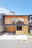 Modern home with Outdoor, Walkways, Front Yard, Small Patio, Porch, Deck, and Wood Patio, Porch, Deck. The house is surrounded by buildings on all sides except its south facade, which faces the street. An expansive operable window is key for effective ventilation during hot summer months. Additionally, a cantilevered balcony shelters a carport, bike storage, and even a playful swing. Photo of Yanagisaki House