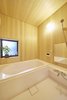 Modern home with Bath Room, Drop In Tub, Open Shower, and Wall Lighting. The bathroom's sauna-like interior includes a deep Toto bathtub—characteristic of traditional Japanese baths. The wooden hiba paneling, chosen because it is more water resistant than hinoki, is specific to the Northern Aomori region of Japan. Photo 6 of Yanagisaki House