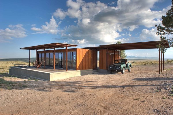 The house has two modules: a living space on the left and a utilities, laundry, and outdoor kitchen on the right.