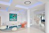 Modern home with Living Room, Accent Lighting, Floor Lighting, Chair, Ottomans, Rug Floor, Sectional, and Coffee Tables. Pillars and a spiral staircase act as modern interpretations of ancient Greek design themes. The orange Coralla chair was designed by the Campana Brothers for Edra and makes a sculptural statement. Photo 7 of Myconian Ambassador Hotel