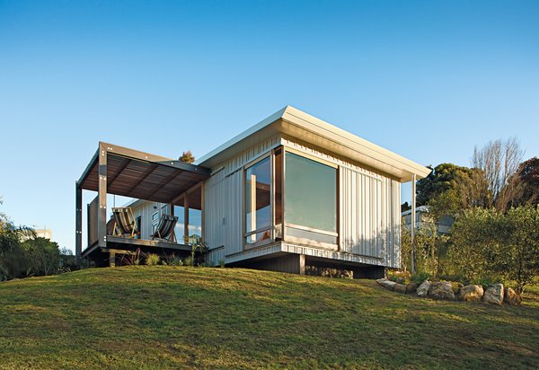 A compact prefab vacation home in the seaside community of Onemana Beach is clad in plywood and vertical timber battens finished in Resene’s Lumbersider paint in Foam.