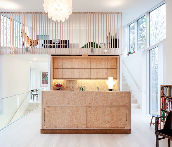 Carpenter Matti Salminen, a family friend, built the birch cabinets and island for the kitchen of a new home outside of Helsinki. The architect, Tuomas Siitonen, situated a lofted family room on the mezzanine above.
