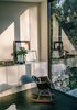 Modern home with Living Room, Chair, Storage, and Ceramic Tile Floor. The home’s deep setback from the street means the couple can leave the large windows undressed to maximize light throughout the day Photo of Eames Molded Chairs