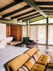 Modern home with Bedroom, Bed, Chair, Dark Hardwood Floor, and Night Stands. A tub zone lined in redwood connects to the master bedroom, which is furnished with a vintage Sergio Rodrigues lounge chair and Voyage Immobile seats from Roche Bobois. Photo of 47+ Midcentury Modern Homes Across America