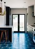 Modern home with Kitchen, Engineered Quartz Counter, Cement Tile Floor, and Pendant Lighting. Vintage lover Sarah Benson worked with local firm Bright Designlab to gently update her 1925 home in Portland, Oregon. In the kitchen, Moroccan cement tiles featuring a blue Hex Dot pattern by Popham Designs cover the floor. Photo of A 20th Century Juxtaposition