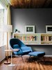 Modern home with Living Room, Floor Lighting, Medium Hardwood Floor, Bookcase, Ottomans, Storage, Shelves, and End Tables. A walnut-topped table and Womb chair, both by Eero Saarinen for Knoll, offer a cozy spot for reading. Photo of 47+ Midcentury Modern Homes Across America