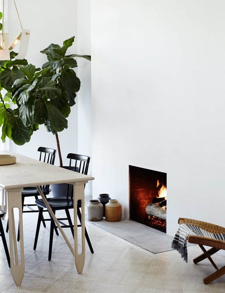 Shaker-style Salt chairs by Tom Kelley join a custom-sized Etoile dining table and Tsuru Flush Mount III pendant, both by Materia Designs.