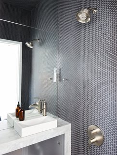 The wet bathroom, clad in Savoy penny tile by Ann Sacks, helped optimize the home’s petite footprint.