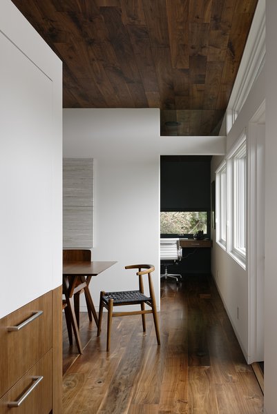 Webbed-seat chairs by John Vogel bookend an expandable walnut dining table from West Elm.