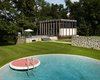 The new pool house and transformed barn that were created by Roger Ferris + Partners during a recent renovation, work together to create a courtyard that borders the original swimming pool. While a very similar circular pool can be found at the Glass House, this one features a lily pad diving platform that's finished with red tile. Photo 10 of Wiley House modern home