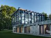 Shown here is a view of the stone and concrete structure that supports the cantilevered glass pavilion. The bottom section holds four bedrooms, bathrooms, and a sitting room. The glass and wood pavilion on top houses a combined living, dining, and kitchen space—all which is surrounded by 15-foot-tall windows. Photo 3 of Wiley House modern home