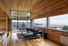 Modern home with Living Room, Floor Lighting, and Ceiling Lighting. “At Sliding House, the outside world is more present,” says Rhonda, “always visible through the sliver of window that runs across the length of the house and down to the ground.” The living area’s Carter leather sectional is by Gus Modern, and the boat carving is by local folk artist Bradford Naugler. The family sought to source Canadian furnishings and materials as much as possible. Photo 7 of Sliding House