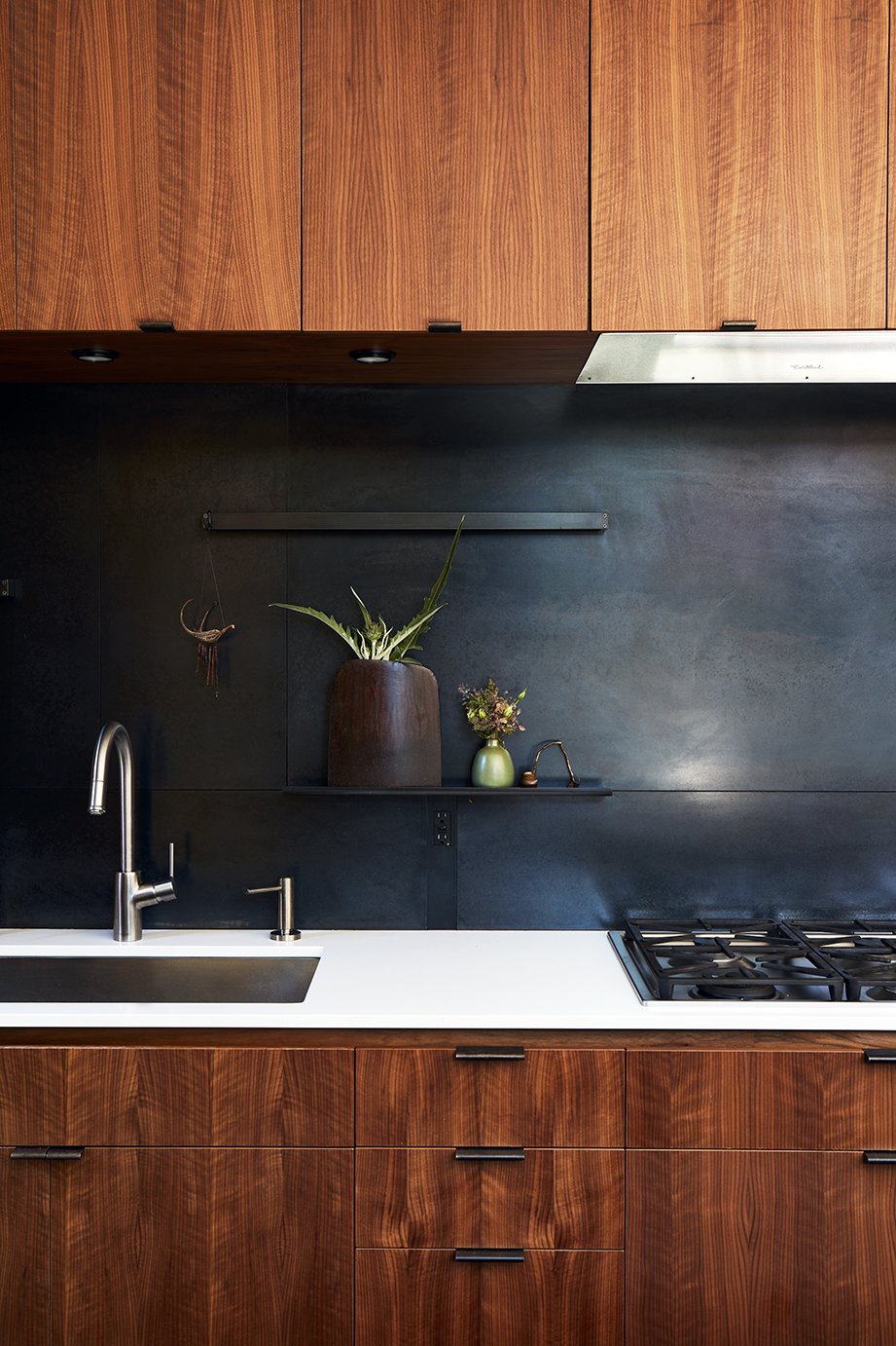 The metal backsplash and drawer pulls were fabricated by 12th Avenue Iron; the cooktop is by Miele.