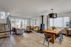 After gutting the interior to create an open floor plan, the Habilis crew installed reclaimed wood flooring that the homeowners had sourced. They painted the walls Strong White by Farrow & Ball and installed a custom metal stairs railing from local welder Joan of Arc. The stove is a Hwam Classic 7. Photo of Frischkorn Ranch modern home