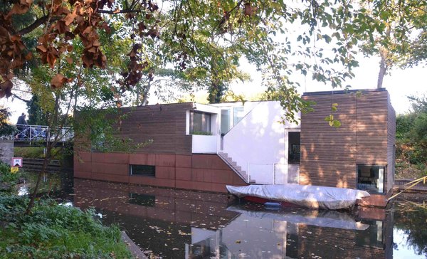 Anchored beside a wooded parkland, this houseboat in the Netherlands was designed by BYTR Architects.