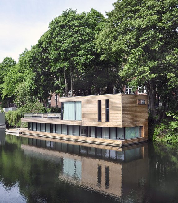 Exterior, Flat RoofLine, Boathouse Building Type, and Wood Siding Material In Hamberg, Germany, Houseboat on the Eilbekkanal is enveloped in sliding timber slats, creating a constant connection between the interior and the exterior.&nbsp;