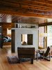 Modern home with Living Room, Two-Sided Fireplace, Light Hardwood Floor, Chair, End Tables, Recliner, Floor Lighting, and Lamps. Bruce Livingstone’s seaside getaway in British Columbia features a remarkably open layout. The master bedroom flows into the living room, where Griffin lounge chairs by Lawson-Fenning face a fireplace clad in glass fiber–reinforced concrete panels by Wiersma Masonry. Photo 3 of Madrona