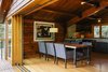 Modern home with Dining Room, Chair, Table, Light Hardwood Floor, Ceiling Lighting, Table Lighting, and Lamps. On the main floor, custom sliders by Oakridge Windows & Doors open to a table and chairs designed by Paquette and built by Conrad Contracting. The wood paneling on the walls was salvaged from the original structure and resawn; each piece was scuffed with fine sandpaper and coated with Projectol. Photo 5 of Madrona