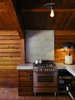 Modern home with Kitchen, Wood Cabinet, Concrete Counter, Range, Ceiling Lighting, and Table Lighting. A Column lamp by Apparatus and concrete countertops join a Bertazzoni propane range. The brass pendant is by Workstead. Photo 6 of Madrona