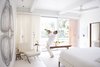 Modern home with Bedroom. Custom curtains by Katie Koch Home offer privacy in the master suite, where Ron plays the trumpet. The couple own a mix of new and vintage Mies van der Rohe Barcelona chairs. Photo 4 of Emerald Street Residence