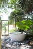 Modern home with Outdoor and Hot Tub Pools, Tubs, Shower. Outdoor Tub: A tucked-away bathtub provides a private backyard oasis. “We kind of got carried away,” resident Maury Strong recalls of the decision to place the 59-inch freestanding Keren basin outdoors. “My view was, ‘Let’s just do it all.”’ The extra effort paid off—the outdoor bath is among her grandchildren’s favorite parts of the house. Her husband, Ron Caron, also enjoys relaxing there. Photo 9 of Emerald Street Residence