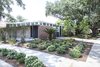 Modern home with Exterior, House Building Type, Flat RoofLine, and Brick Siding Material. Plantings: Evans + Lighter Landscape Architecture, contractor Sandra Tomasetti, and architecture firm studioWTA collaborated to develop a roofline without gutters above the walkway and carport. Instead, water is channeled to feed the garden. The result is a California-inspired yard with geometrically laid-out plantings rather than grass. “It’s rows of green with mulch permeating,” Maury says. Photo 10 of Emerald Street Residence