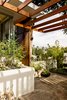 Andrew worked with contractor Miguel Perez to rebuild the home’s redwood trellis, matching the stain to the adjoining slat screen, which is original. Photo 7 of The Romano-Ferrer Residence modern home