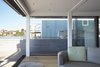 Modern home with Large Patio, Porch, Deck, Hanging Lighting, and Living Room. A touch of a button summons the bar from its berth in the lower level, where the home theater also resides when not in use; the systems are custom installations by Classic Innovations. Photo 4 of Floating Dreams Residence