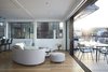 Modern home with Large Patio, Porch, Deck, Hanging Lighting, Light Hardwood Floor, Sofa, and Living Room. The living room furniture is from Roche Bobois. Photo 6 of Floating Dreams Residence
